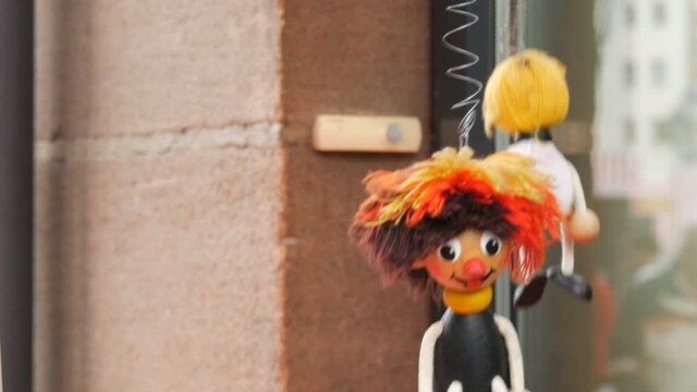 Funny wooden toys string puppet moving around that jump on street of Nuremberg, Germany