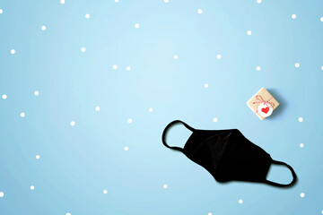 Face mask with a Christmas gift box - flat lay