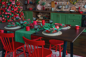 Decorated Christmas dinner table, wooden red chairs around. Table setting for celebration Xmas and New Year Holidays. Festive table at home with Christmas tree on background. Selective focus