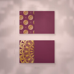 Burgundy business card template with luxurious gold ornaments for your business.
