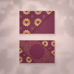 Burgundy business card template with vintage gold pattern for your contacts.