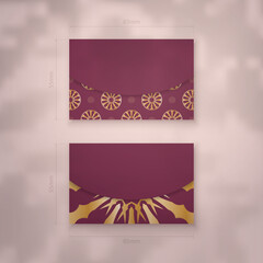 Burgundy business card with abstract gold ornaments for your brand.