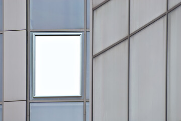 Rectangular sign on the building. Copy space and space for text. Mockup for design. Blank template for advertising. White frame on a glass case. Advertising on the window of the mall.