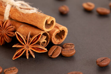 coffee beans, star anise and cinnamon on a black background. close-up