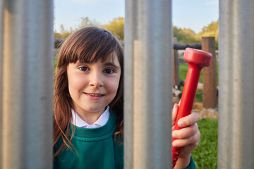 young girl with school unifome playing music on a xylophone in a playground