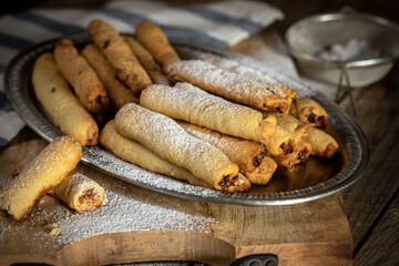Rolls with nut filling made from shortcrust pastry, sprinkled with powdered sugar.
