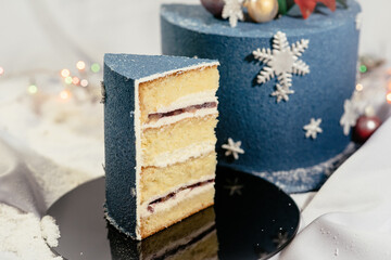 Delicious cream cake in cut. Festive Christmas cake decorated with spheres and snowflakes. New Year's dessert