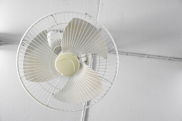 An old electric fan which installed on the ceiling of room, selective and soft focus.