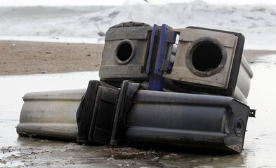 Fototapeta na wymiar garbage cans thrown on the beach, strong tides, climate change,