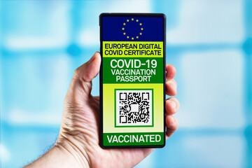 Smartphone of a Tourist showing immunity digital passport that certifies their vaccination against the COVID-19. Traveler show health european passport with vaccination certification coronavirus