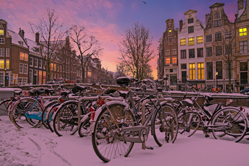 Naklejka premium Snowy bikes in Amsterdam the Netherlands at sunset