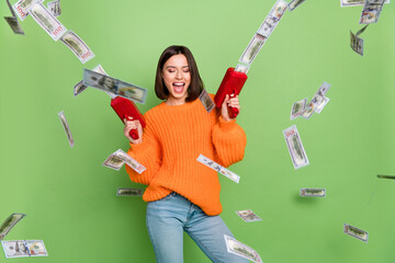 Photo of excited lady shoot gun air fly money credit cashback deposit wear orange jumper isolated...