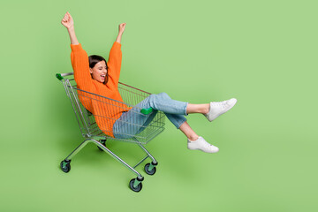 Portrait of attractive cheerful crazy girl riding cart having fun fooling isolated over bright...