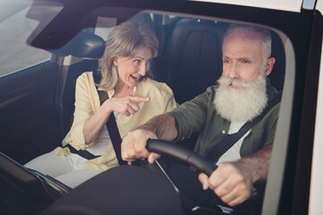 Photo of annoyed unhappy pensioner friends dressed casual shirts quarreling riding auto outdoors...