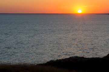 Beautiful sunset at sea. The sun sets over the horizon. Seascape.