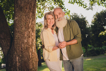 Photo of wife husband happy old couple wear sportswear dance hold hands smile outdoors outside park in forest