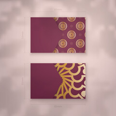 Business card template in burgundy color with abstract gold ornaments for your personality.