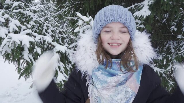 Portrait of a happy, blue-eyed teenage girl in a snowy park