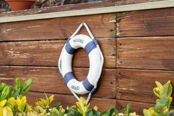 mini lifebuoy with the words Welcome aboard hanging on a wood-trimmed fence