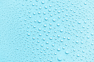 Water drops on a blue background. Round drops on waterproof material. Texture. The concept of freshness and purity. Splashes, condensation.