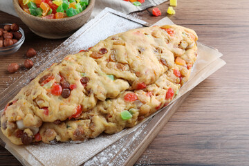 Unbaked Stollen with candied fruits and raisins on wooden table, closeup