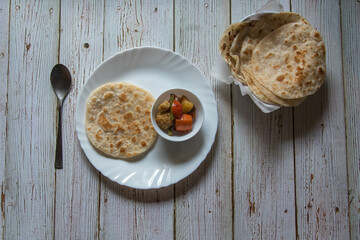 Indian breakfast menu paratha and sabji or vegetable masala served in a plate. Top view.