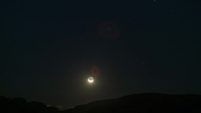 Time lapse of crescent moon rising over horizon in Mojave Desert, California 