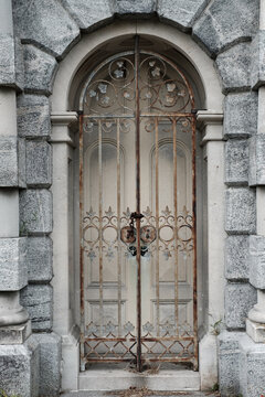Rusting iron Gated doorway surrounded by granite archway