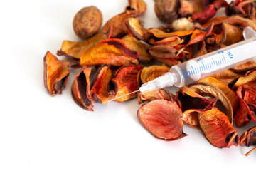 Preventative healtcare. Fall is time for flue shots. Syringe with autumn leaves on white background. Health care during cold and flu season