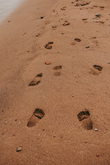 Fototapeta na wymiar Human footprints in the sand. Yellow sand .Summer holidays. Orange sand. Yellow sand