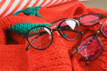 several different stylish eye glasses on a red knitted hat, christmas sale in the optics store