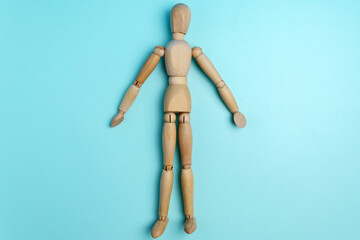 Wooden figure mannequin on a blue background top view. Flat lay