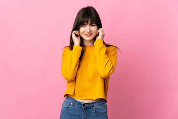 Young Ukrainian woman isolated on pink background frustrated and covering ears