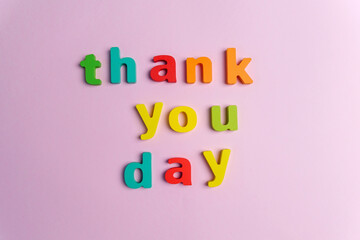 Creative flat play with the text thank you day. Top view. Pink background