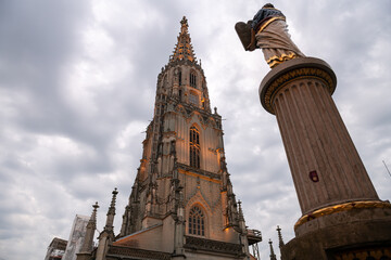 Fototapeta na wymiar Travel to Switzerland. Berner Münster cathedral with amazing architecture tower photographed during a cloudy morning. Landmark of this city from Bern.