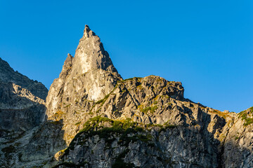 The eastern wall of the Monk, lit by the morning sun. There are many climbing routes with different levels of difficulty.