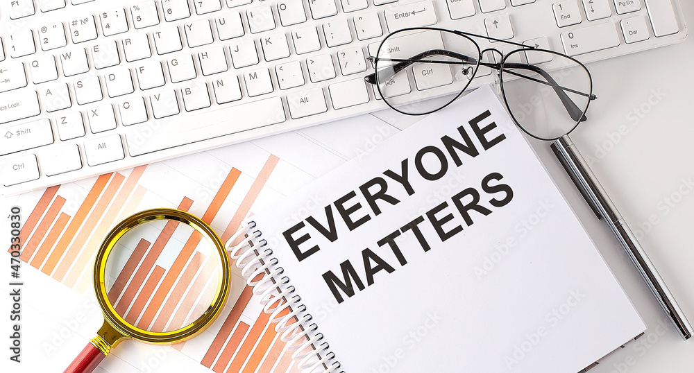 Poster everyone matters text written on a notebook with keyboard, chart,and glasses