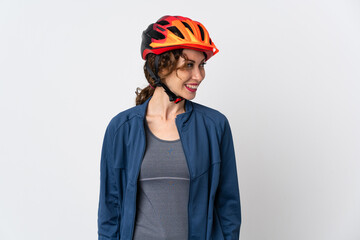 Young cyclist woman isolated on white background looking to the side and smiling