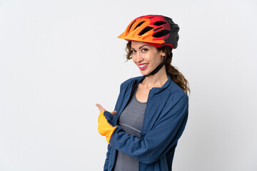 Young cyclist woman isolated on white background pointing back