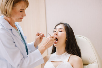 Obraz na płótnie Canvas Woman having teeth examined at dentists
