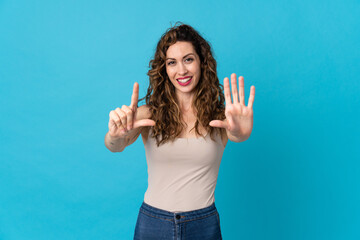 Fototapeta premium Young caucasian woman isolated on blue background counting seven with fingers