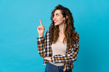 Young caucasian woman isolated on blue background pointing up a great idea