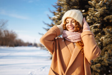 Happy woman in winter style clothes walking in the snowy forest. Nature, holidays, rest, travel...