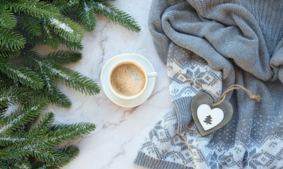 coffee cup, sweater, heart decor, fir tree branches on marble background. Christmas and new year holidays concept. festive winter season. flat lay