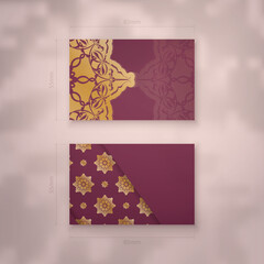 Presentable burgundy business card with antique gold ornaments for your business.