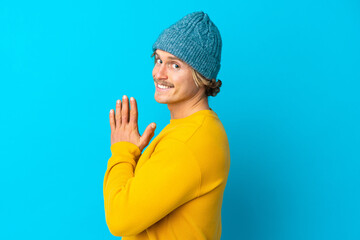 Handsome blonde man isolated on blue background scheming something