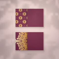 Presentable burgundy business card with antique gold pattern for your business.
