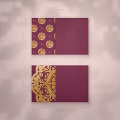 Presentable burgundy business card with Indian gold pattern for your business.