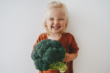 Child girl with broccoli healthy food vegan eating lifestyle organic vegetables plant based diet...