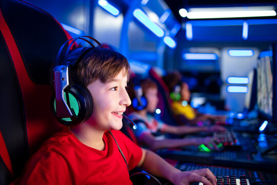 Close Up View Of Happy Gamer Boy With Headset Playing Video Games On The Computer In Game Room.